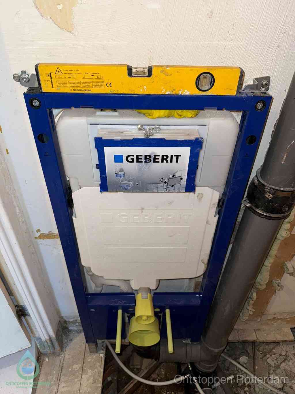 Een Geberit inbouwreservoir met frame voor een hangtoilet tegen de wand, met de afvoerbocht naar de vloer, kenmerkend voor een verstopt hangtoilet in Rotterdam