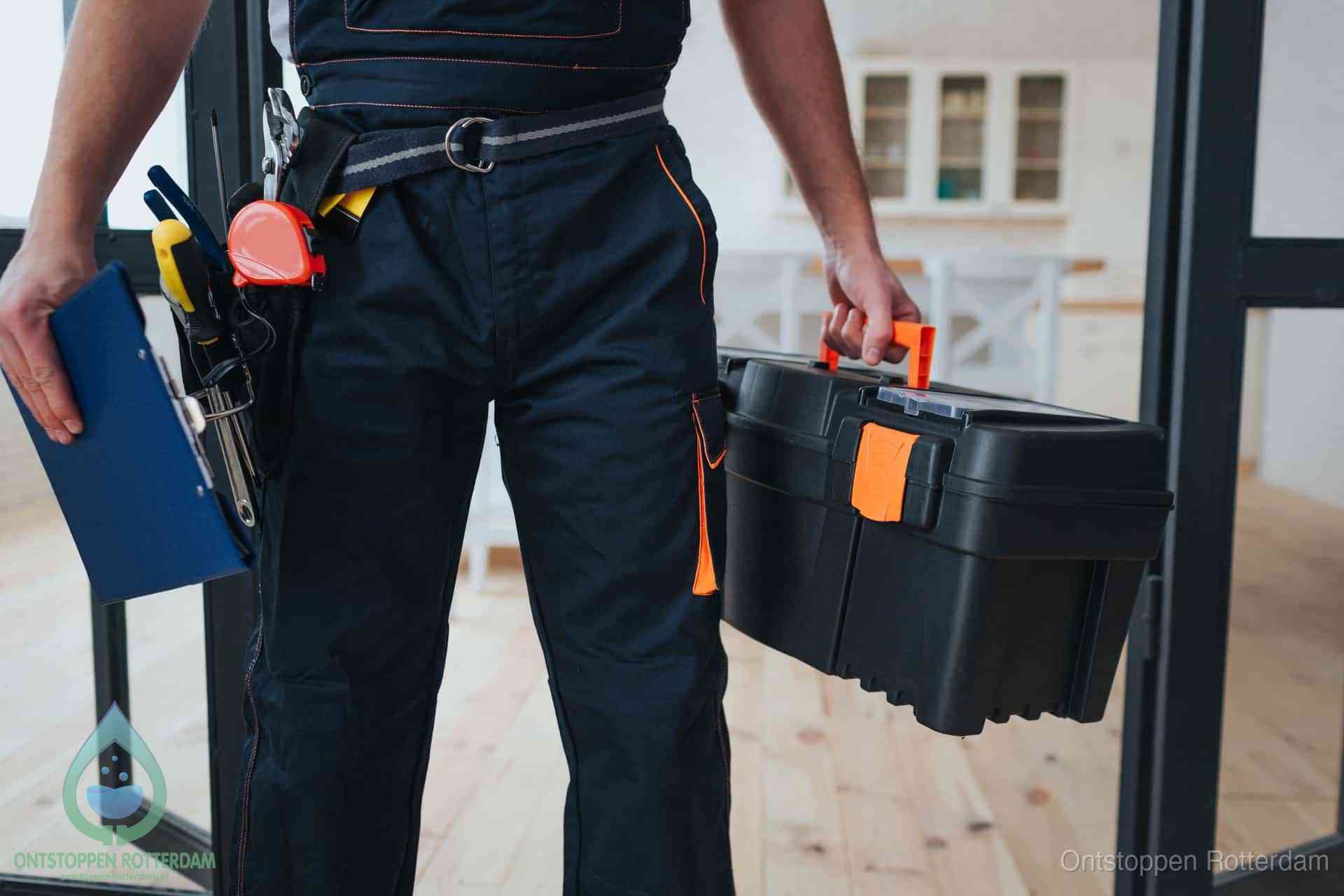 Een monteur met gereedschapsriem en klembord in een keuken, klaar om een transparante prijs voor het gootsteen ontstoppen in Rotterdam te geven