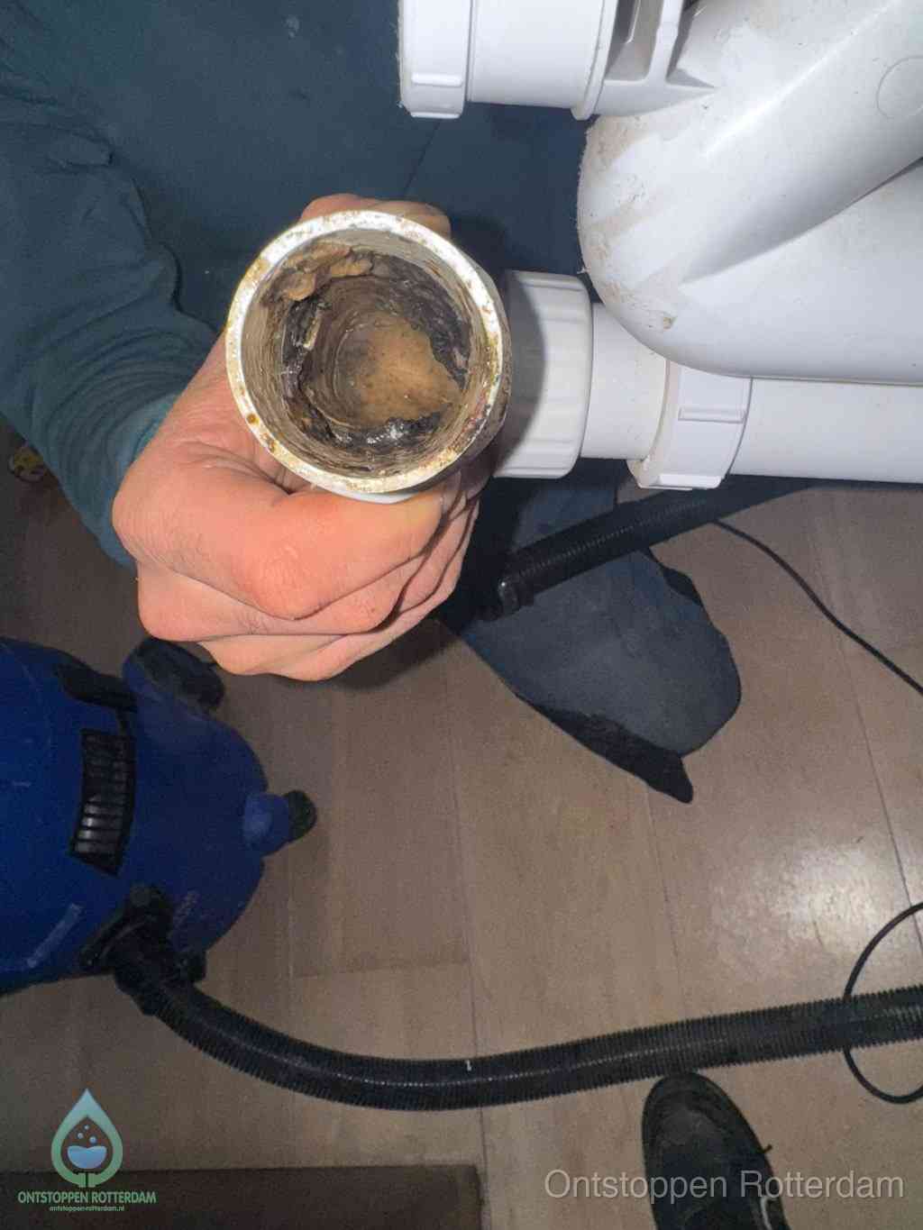 Een losgekoppelde afvoerbuis die van binnen volledig is dichtgeslibd met vet en aanslag, de meest voorkomende oorzaak van een verstopte gootsteen in Rotterdam