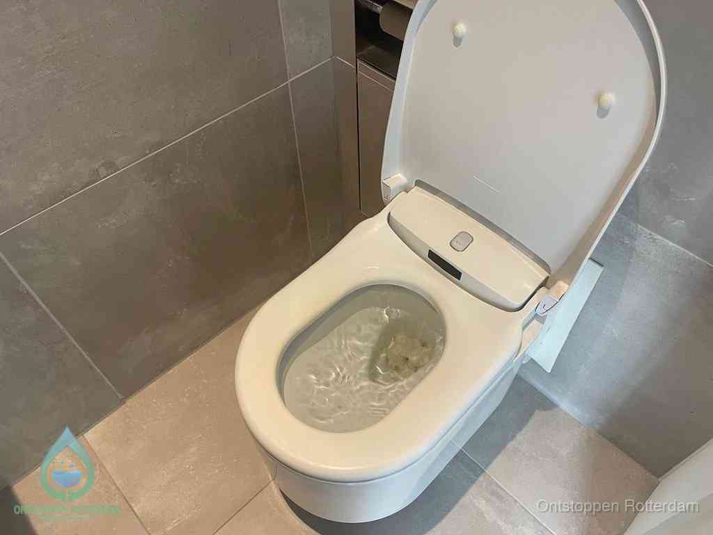 Een toiletpot vol troebel water met drijvend papier en restanten, de meest voorkomende oorzaak van een verstopte wc in Rotterdam