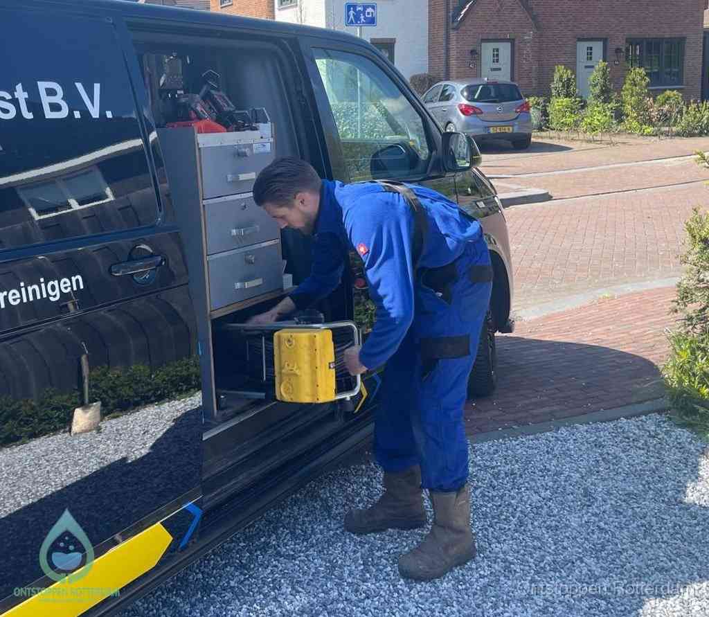 Een monteur pakt apparatuur uit de bedrijfsbus voor service aan huis, het moment om een professional in te schakelen voor een verstopte wc in Rotterdam