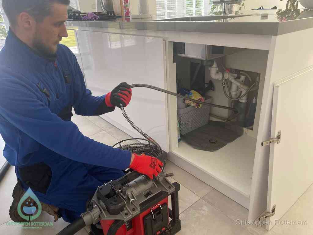 Een monteur reinigt de keukenafvoer grondig met een veermachine om terugkerende gootsteenverstoppingen te voorkomen in Rotterdam